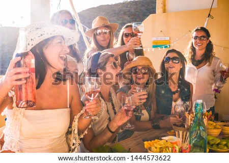 Happy group of people celebrate a birthday. Smiling women with red wineglass. wooden table, food and drink. Friendship concept
