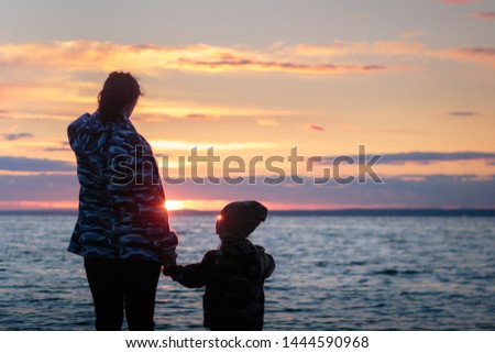 Mother and her little child at the sunset