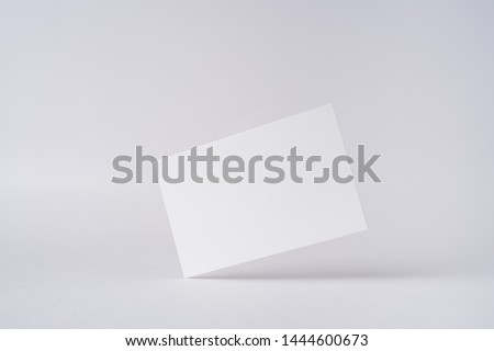 Design concept - front view of surreal white business card float on mid air isolated on white background for mockup, it's real photo, not 3D render