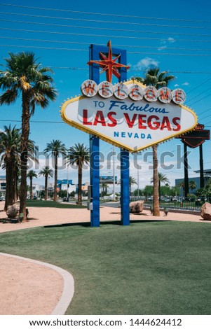 vintage style of wide angle view of famous welcome to fabulous nevada sign standing under blue sky. colorful billboard at southern end of Las Vegas Boulevard and surrounding by beautiful coconut palm