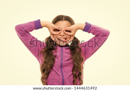 Cheerful grimace. Girl holding fingers like glasses mask superhero or owl. Play game with mask superhero. Child cheerful mood grimace with mask. Pretend be fantastic hero. Kid hide face finger mask.