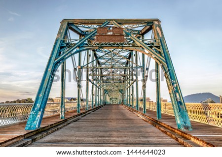 Now a pedestrian crossing, the Walnut Street Bridge, built in 1890, spans the Tennessee River in Chattanooga with historic Lookout Mountain in the background early in the morning.