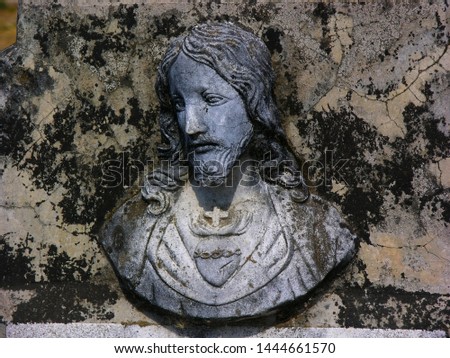 Image of jesus christ carved in gray stone placed on a gravestone in catholic pantheon