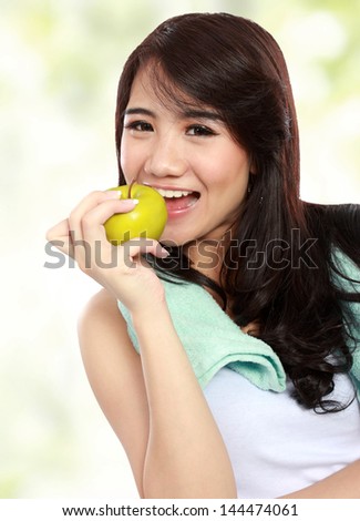 Portrait of confident happy fitness women in sportswear and eat green apple