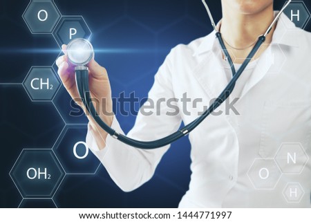 Young female doctor using stethoscope on blurry medical background. Medicine and occupation concept