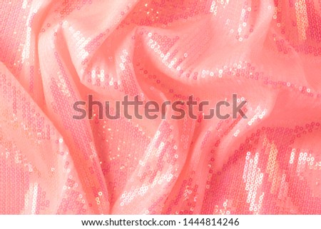Photography on the theme of the trend color 2019. Large shiny glossy orange sequins fully filling the background space.