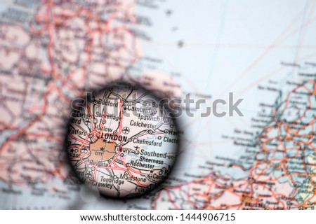 London UK capital close-up through a magnifying glass on the background of a blurred geographical map of Europe. The concept of news and events screensaver.