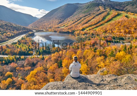 Woman hiking at Artist's Bluff in autumn. View of Echo Lake. Fall colours in Franconia Notch State Park. White Mountain National Forest, New Hampshire, USA Royalty-Free Stock Photo #1444909901