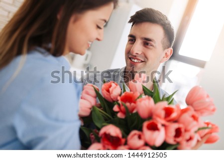 Picture showing man giving flowers to a woman at home. Romantic concept. Woman`s day.