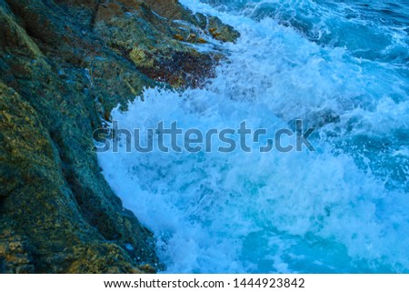 Aerial photography with drone. Sea waves splashing water on the rock.