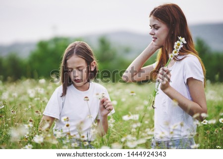 Mom and daughter collects flowers childhood fun nature vacation