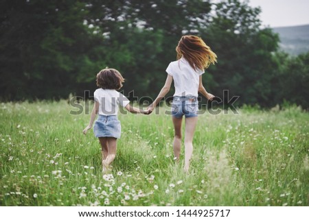 Cute Mom and daughter hold hands nature is joy