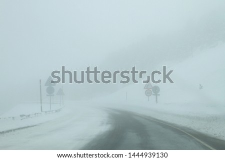 Winter road with snow, ice and fog