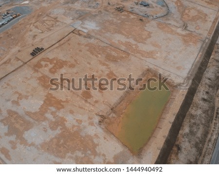 Aerial view of a rain water pond on the construction site during earthworks process.