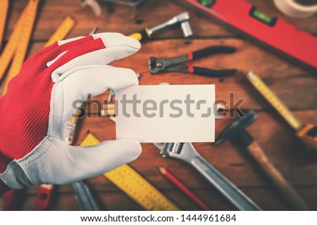 handyman and home repair services - hand holding blank business card over the work tools