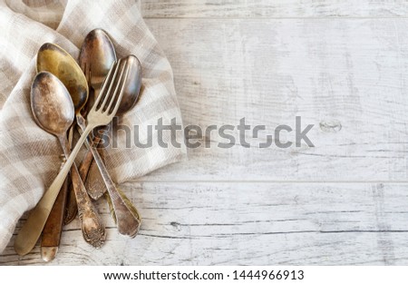 Vintage cutlery and checkered napkin on wooden table, copy space.