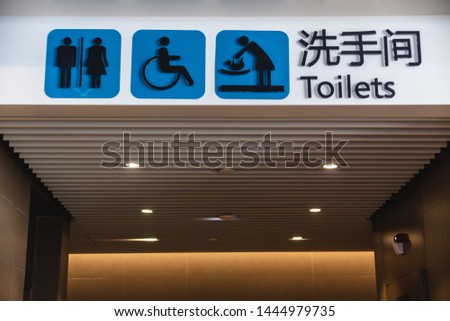 Sign and entrance to the toilet at the Chinese airport. Male, female toilet, room for mother and child, toilet for disabled people. The inscription in Chinese - toilet.