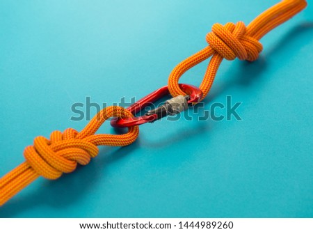Red carbine with clutch. Equipment for climbing and mountaineering. Safety rope. Knot eight. Royalty-Free Stock Photo #1444989260
