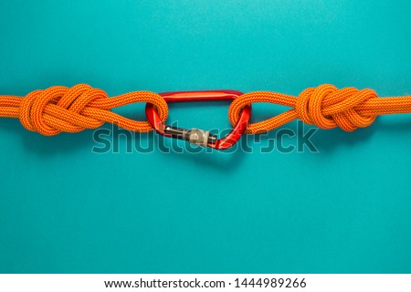 Red carbine with clutch. Equipment for climbing and mountaineering. Safety rope. Knot eight. Royalty-Free Stock Photo #1444989266