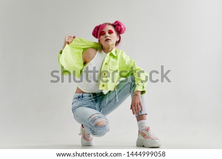 a woman with pink hair in jeans sat down in eighties fashion style
