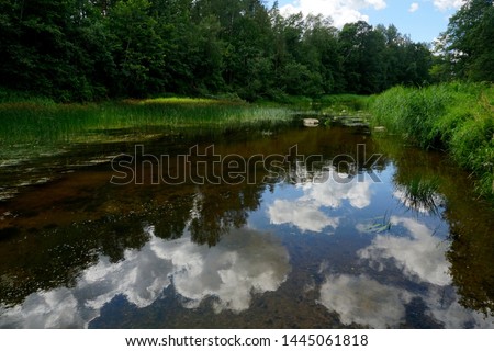 River Ogre with cloud reflections in water, Ogresgals, Latvia        