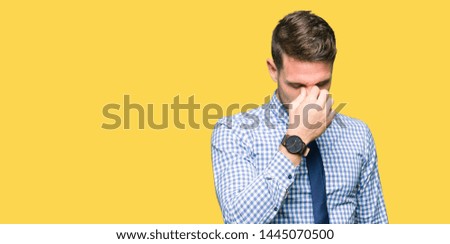 Handsome business man wearing tie tired rubbing nose and eyes feeling fatigue and headache. Stress and frustration concept.