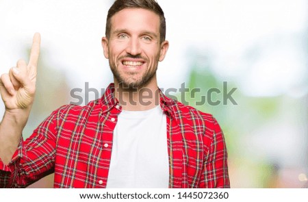 Handsome man wearing casual shirt showing and pointing up with finger number one while smiling confident and happy.