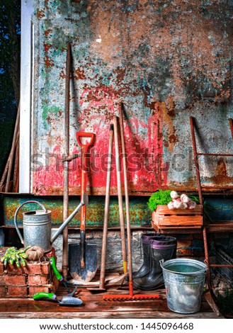 Simple garden tools on the background of the old shabby barn wall 