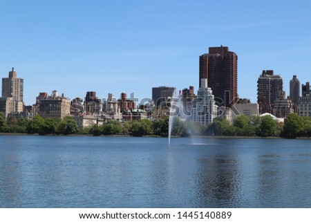 Central Park lake and fountain with Manhattan skyline on the back