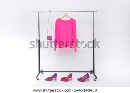 Pink sweater,handbag on hanger with three pair shoes
