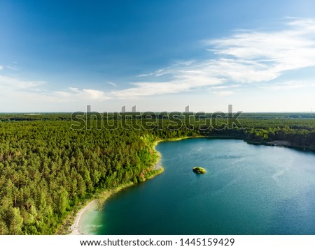 Aerial view of beautiful green waters of lake Gela. Birds eye view of scenic emerald lake surrounded by pine forests. Clouds reflecting in Gela lake, near Vilnius city, Lithuania. Royalty-Free Stock Photo #1445159429