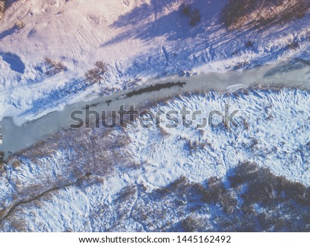 Rural landscape in winter in evening. Fields covered with snow. Aerial view. 