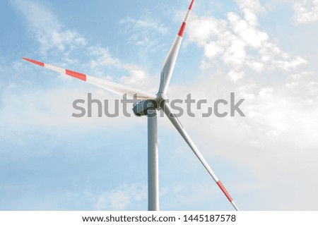 A picture of a windmill overlooking a beautiful blue sky