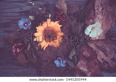 Sunflower and wild flowers in a bouquet on a wooden table close-up
