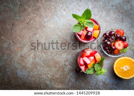 Red wine sangria or punch with fruits and ice in glasses top view. Homemade refreshing fruit sangria.