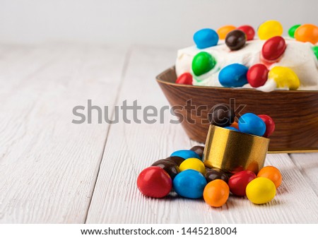 Sweet jelly beans and ice cream on wooden background