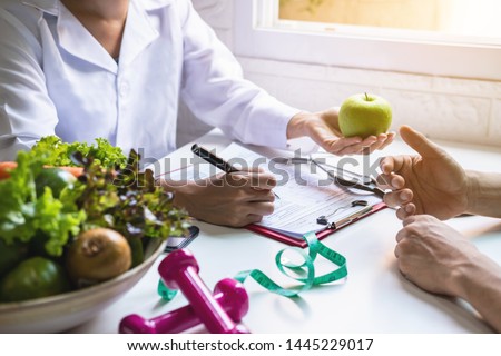 Nutritionist giving consultation to patient with healthy fruit and vegetable, Right nutrition and diet concept Royalty-Free Stock Photo #1445229017