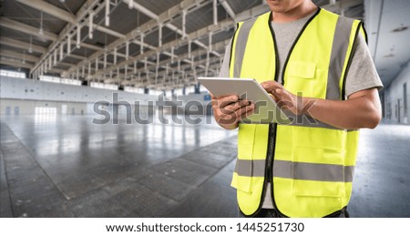 worker hand holding pad for check order pick time in empty warehouse