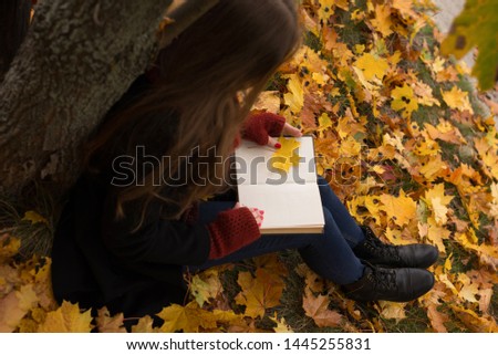The girl with empty book in autumn forest