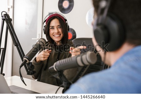 Man and woman in white shirts podcasters interview each other for radio podcast Royalty-Free Stock Photo #1445266640