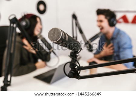 Two radio hosts moderating a live show for radio