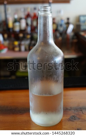 Glass Bottle of Water Sitting on Restaurant Bar