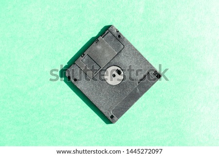black floppy disk on green background. retro magnetic storage