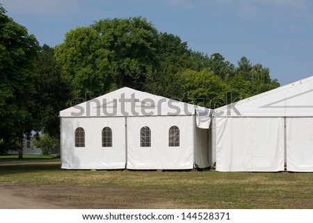 A white party or event tent on a meadow in a public park Royalty-Free Stock Photo #144528371