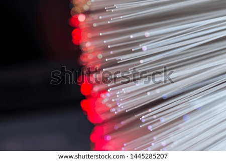 Glowing colorful optical fibres over laptop computer keyboard , image for background.