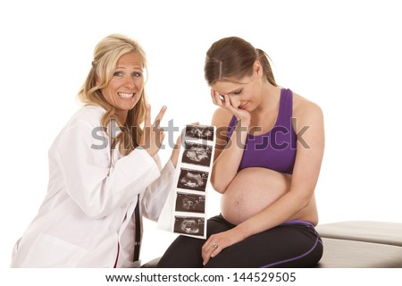 a woman sitting on a bench with her head in her hand because the doctor just told her she is having twins