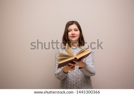 Portrait of young brunette woman with book in her hand
