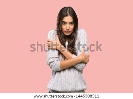 Young hispanic brunette woman freezing over isolated background