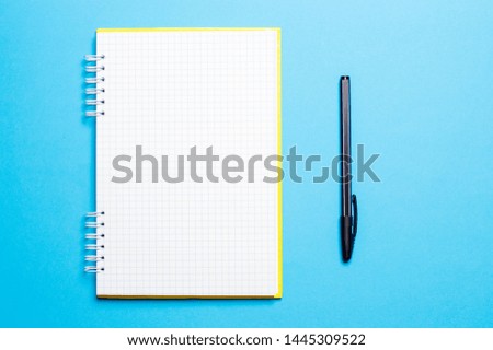 notebook on a blue background with pens