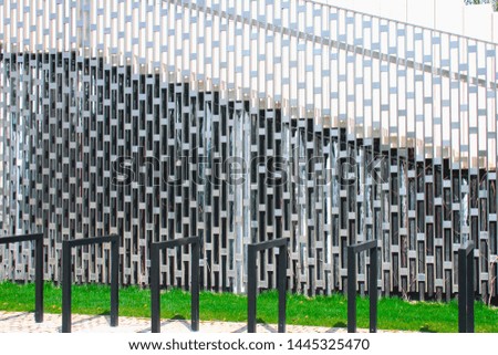 Close-up photo of shiny metal grid structure with shadows as abstract background on the subject of modern architecture, industry or technology.